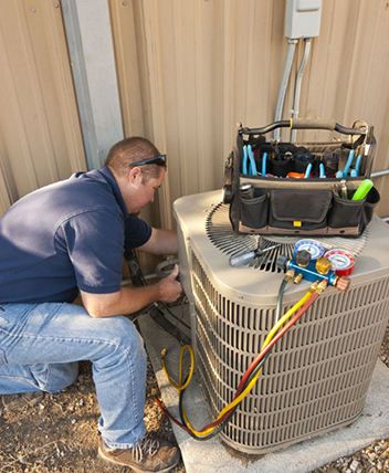 HVAC technician servicing outdoor AC unit with tools.