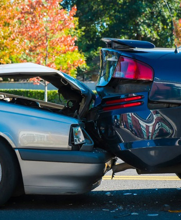 Rear-end car accident scene with vehicle damage.